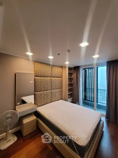 Modern bedroom with balcony and stylish decor in high-rise apartment.