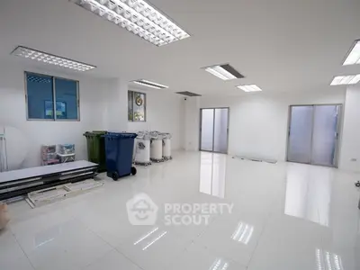 Spacious white tiled room with large windows and fluorescent lighting, ideal for versatile use.