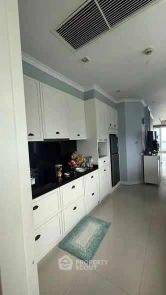 Modern kitchen with sleek white cabinets and black countertops in a stylish apartment.