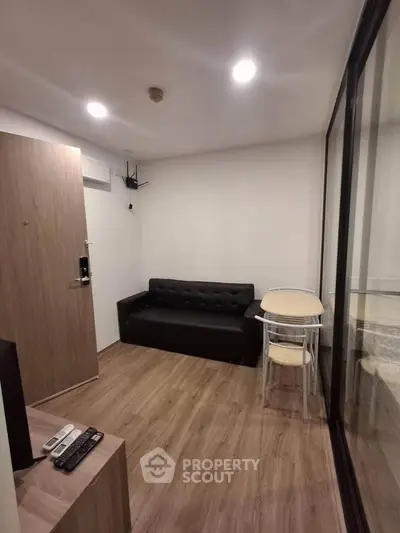 Cozy modern living room with wooden flooring and compact furniture