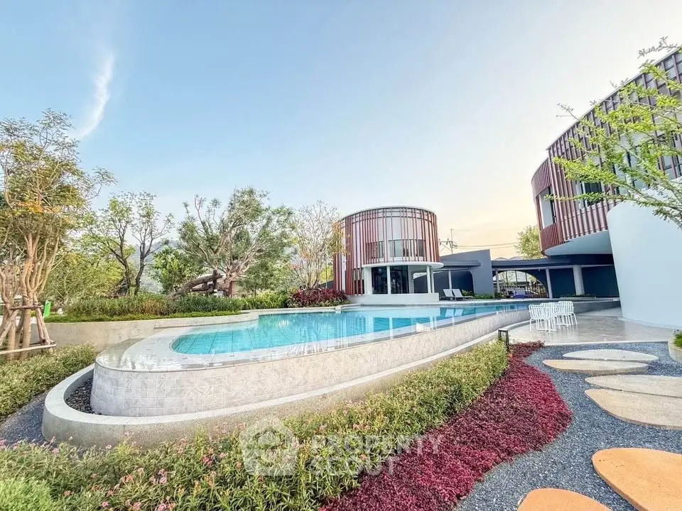 Luxurious modern building with stunning pool and lush garden landscape.