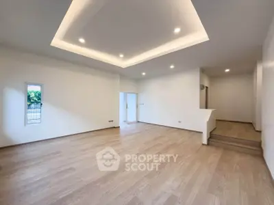 Spacious modern living room with recessed lighting and wooden flooring