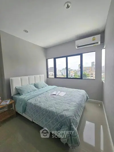 Modern bedroom with large windows and city view, featuring a comfortable bed and air conditioning.