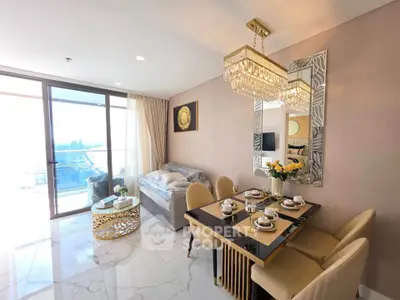 Luxurious living room with elegant dining area and stunning city view from balcony.