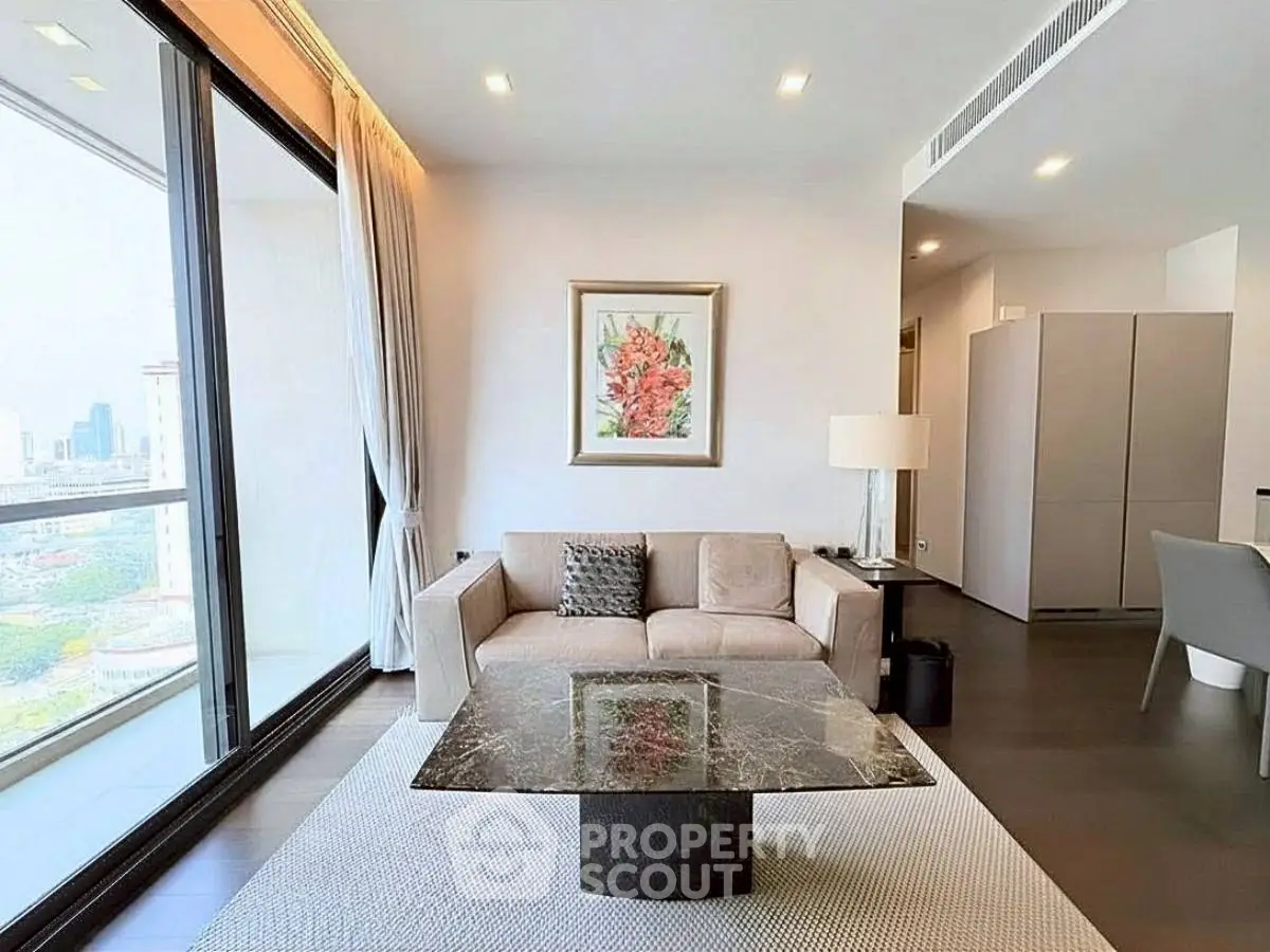 Modern living room with large windows and city view, featuring elegant furniture and stylish decor.