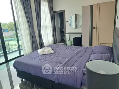 Spacious bedroom with large windows and modern decor, offering a serene and inviting atmosphere.