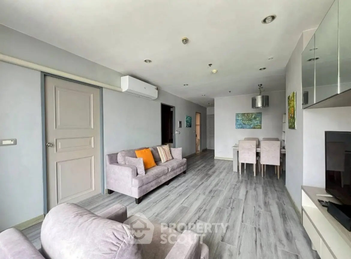 Spacious modern living room with stylish decor and dining area in open layout apartment.