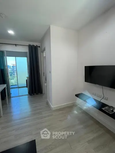 Modern living room with wall-mounted TV and balcony view
