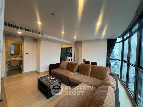 Spacious modern living room with panoramic city views and cozy seating area.
