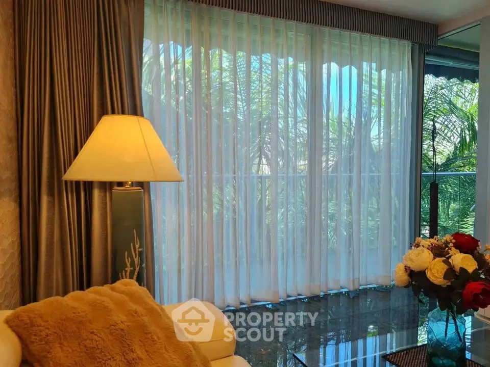 Luxurious living room with elegant decor and large windows offering lush garden views.