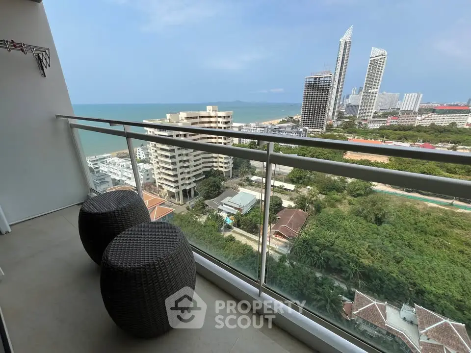 Stunning high-rise balcony with ocean view and modern seating, perfect for relaxation and enjoying the skyline.