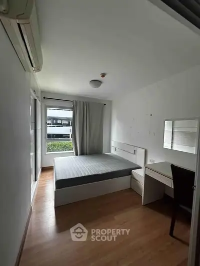 Cozy bedroom with modern furnishings and natural light in a stylish apartment.