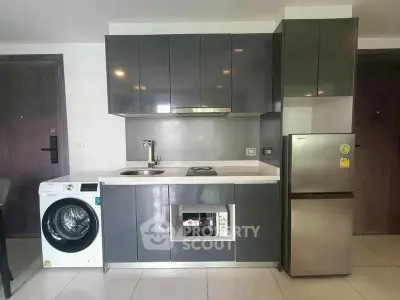 Modern kitchen with sleek cabinetry, built-in appliances, and washing machine in a compact layout.
