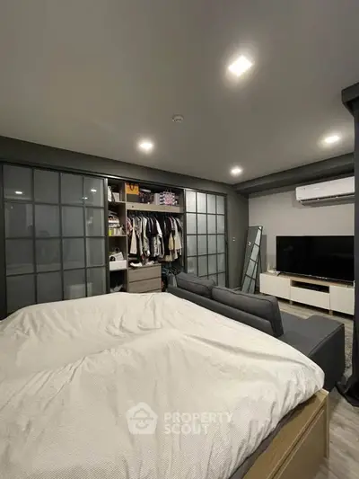 Modern bedroom with built-in closet and sleek entertainment setup
