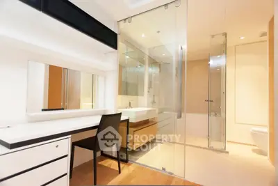 Modern bathroom with glass shower and sleek vanity in luxury apartment.