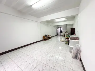 Spacious open-plan living area with tiled flooring and minimal furnishings