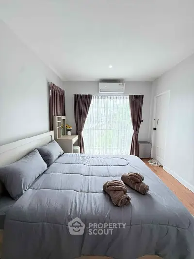 Spacious bedroom with large bed and natural light from window