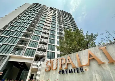 Modern high-rise building with sleek design and prominent signage, showcasing urban living.