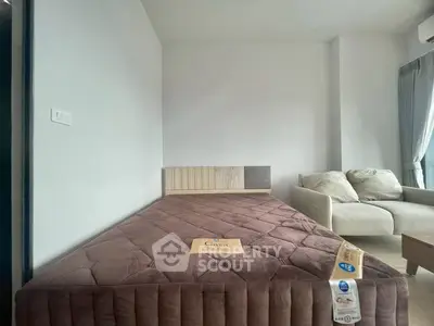 Modern bedroom with cozy bed and stylish sofa in a bright apartment.