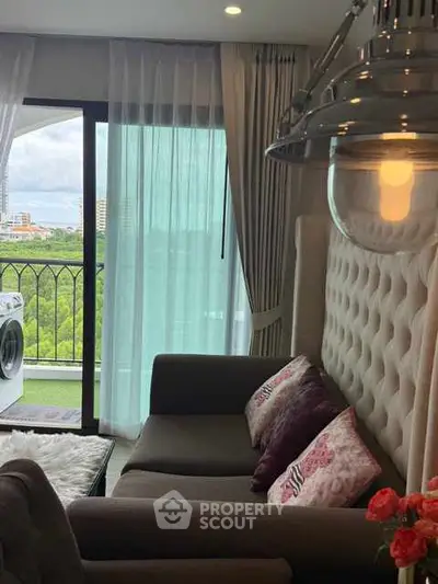 Stylish living room with balcony view and washing machine, perfect for modern living.