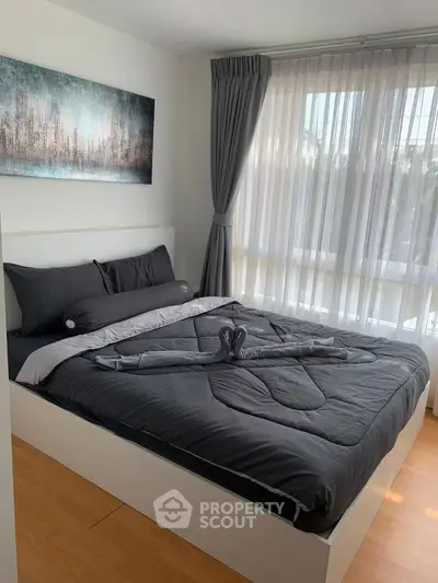 Modern bedroom with stylish decor and large window for natural light