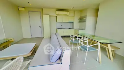Modern open-plan living room with sleek kitchen and stylish furniture in a bright apartment.