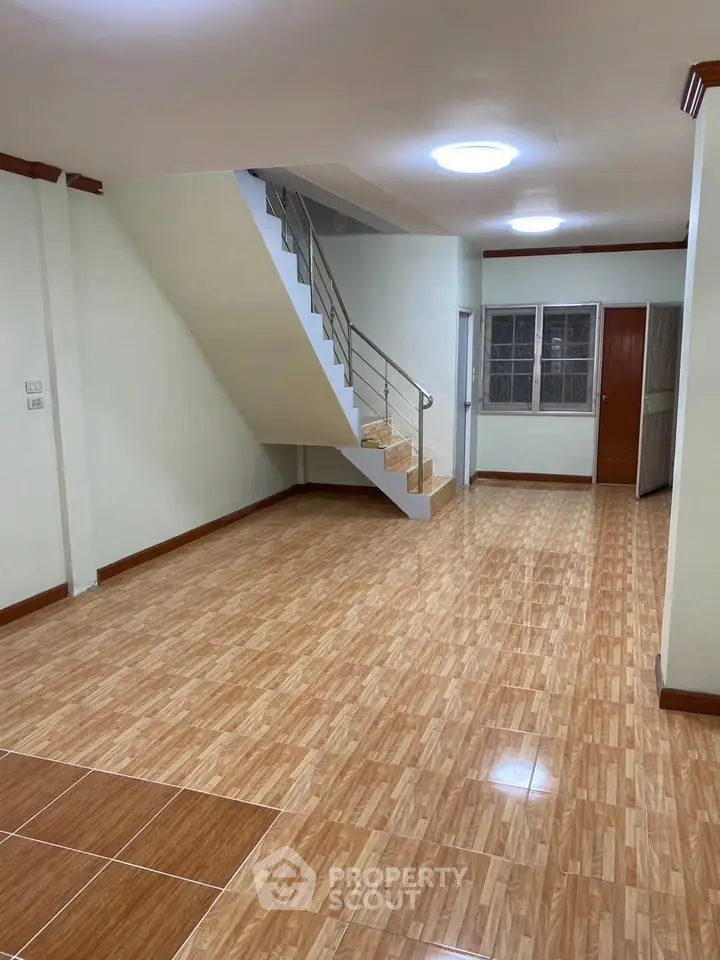 Spacious interior with modern staircase and tiled flooring, ideal for customization.