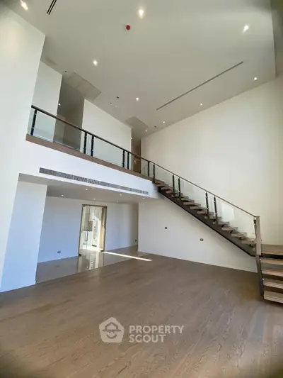 Spacious modern living room with high ceilings and elegant staircase