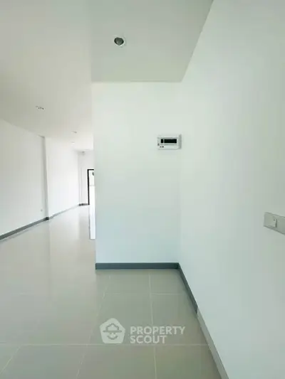Spacious modern interior with sleek white walls and tiled flooring, perfect for customization.