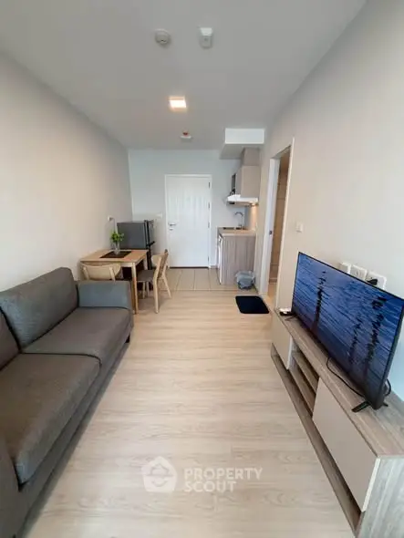 Modern living room with sleek furniture and open kitchen layout in a stylish apartment.