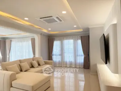 Spacious modern living room with elegant sofa and large windows, perfect for relaxation and entertainment.