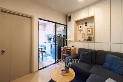 Cozy living room with modern decor and adjacent kitchen in compact apartment.