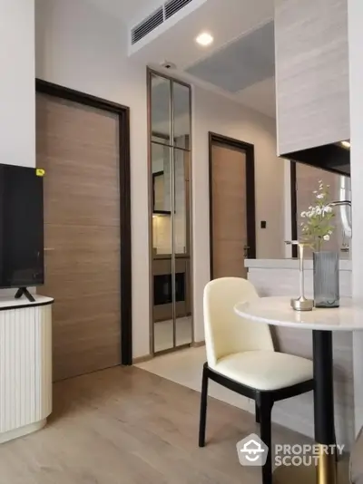 Modern apartment interior with stylish dining area and wooden doors