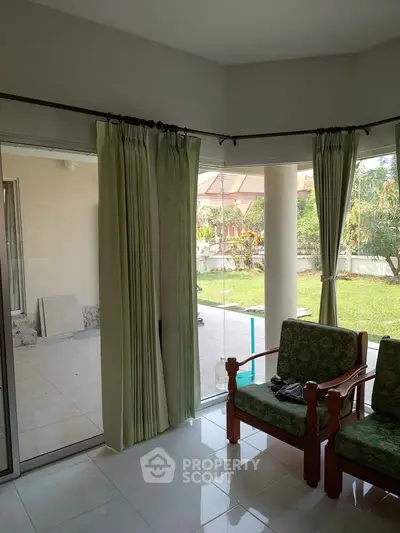 Spacious living room with garden view and elegant curtains in a modern home.