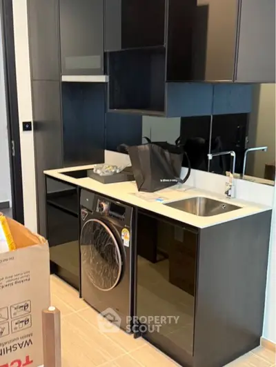 Modern kitchen with sleek black cabinets and built-in washing machine
