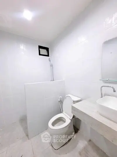 Modern minimalist bathroom with white tiles and sleek fixtures