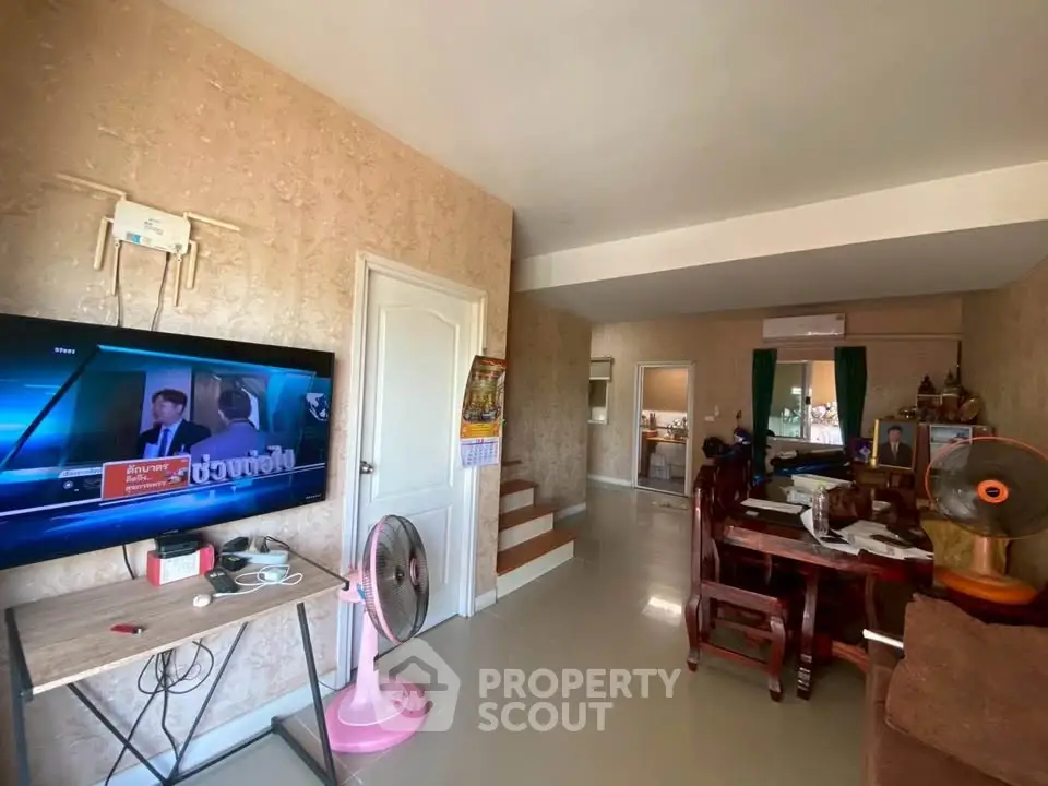 Spacious living room with modern decor and wall-mounted TV, perfect for relaxation and entertainment.
