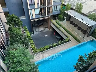 Modern apartment building with pool and lush greenery, offering a luxurious urban lifestyle.