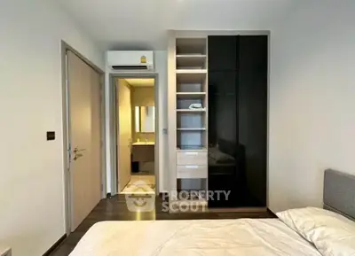 Modern bedroom with sleek wardrobe and ensuite bathroom in a stylish apartment.