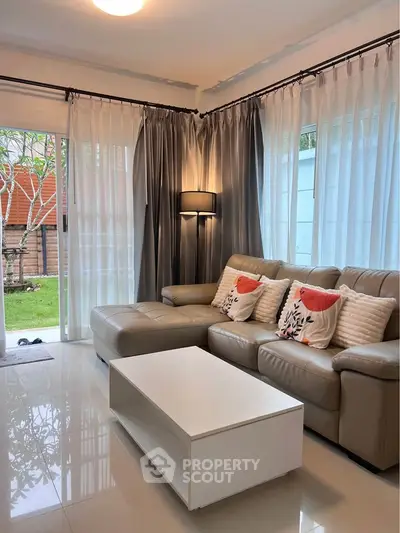 Stylish living room with modern sofa and garden view, perfect for relaxation.