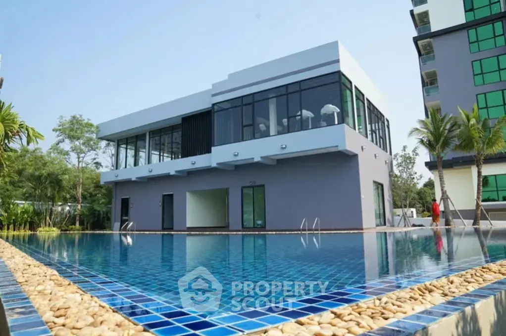 Modern building with pool and lush greenery, perfect for luxury living.