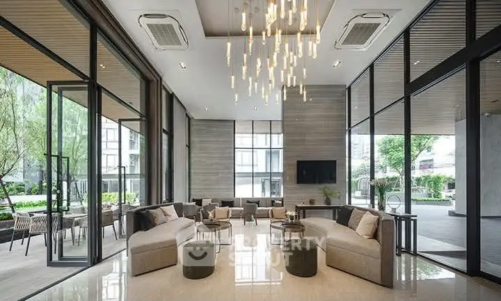 Luxurious modern lobby with elegant seating and stunning chandelier in upscale building.
