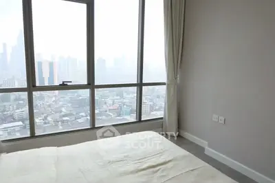 Spacious bedroom with panoramic city view through large windows