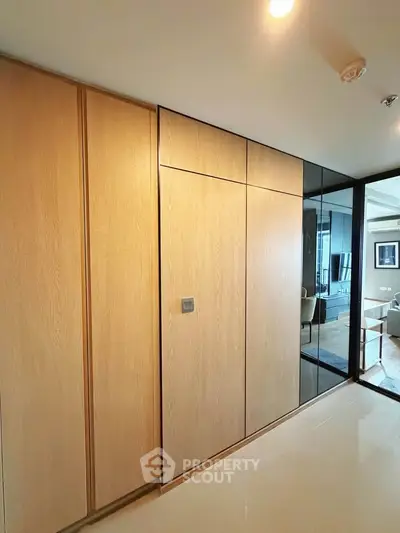 Modern interior with sleek wooden cabinetry and glass accents in a stylish living space.