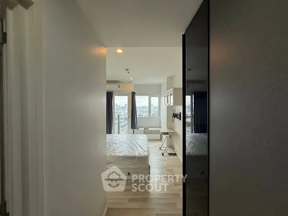 Modern bedroom with city view and sleek design, featuring large windows and minimalist decor.