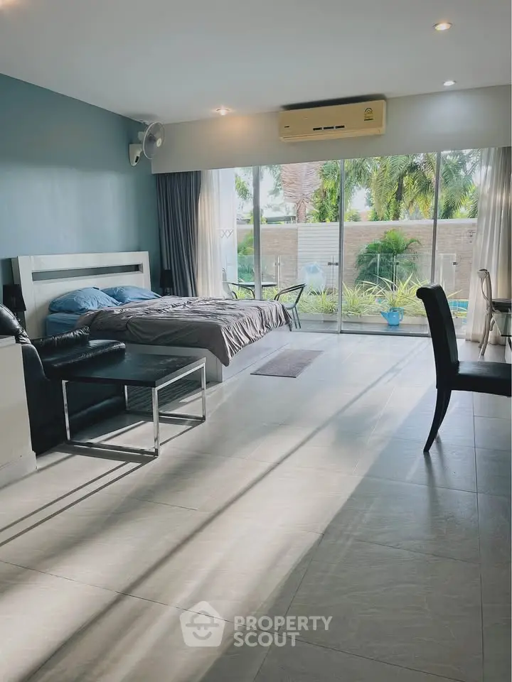 Spacious bedroom with pool view and modern furnishings