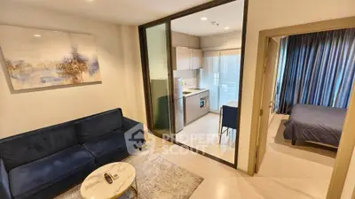 Modern apartment with open layout, featuring cozy living room and compact kitchen.