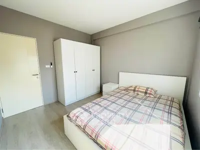 Bright minimalist bedroom with modern wardrobe and cozy bed