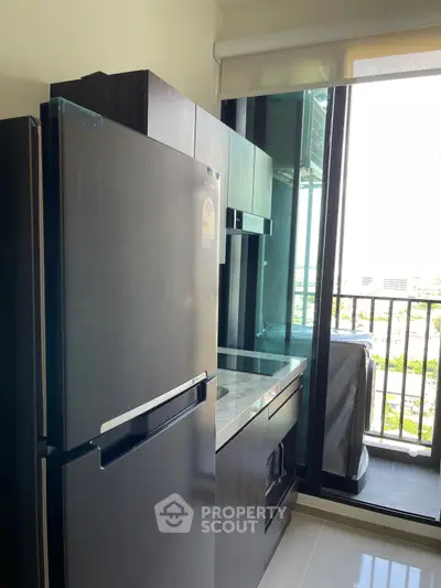 Modern kitchen with sleek appliances and balcony view in urban apartment
