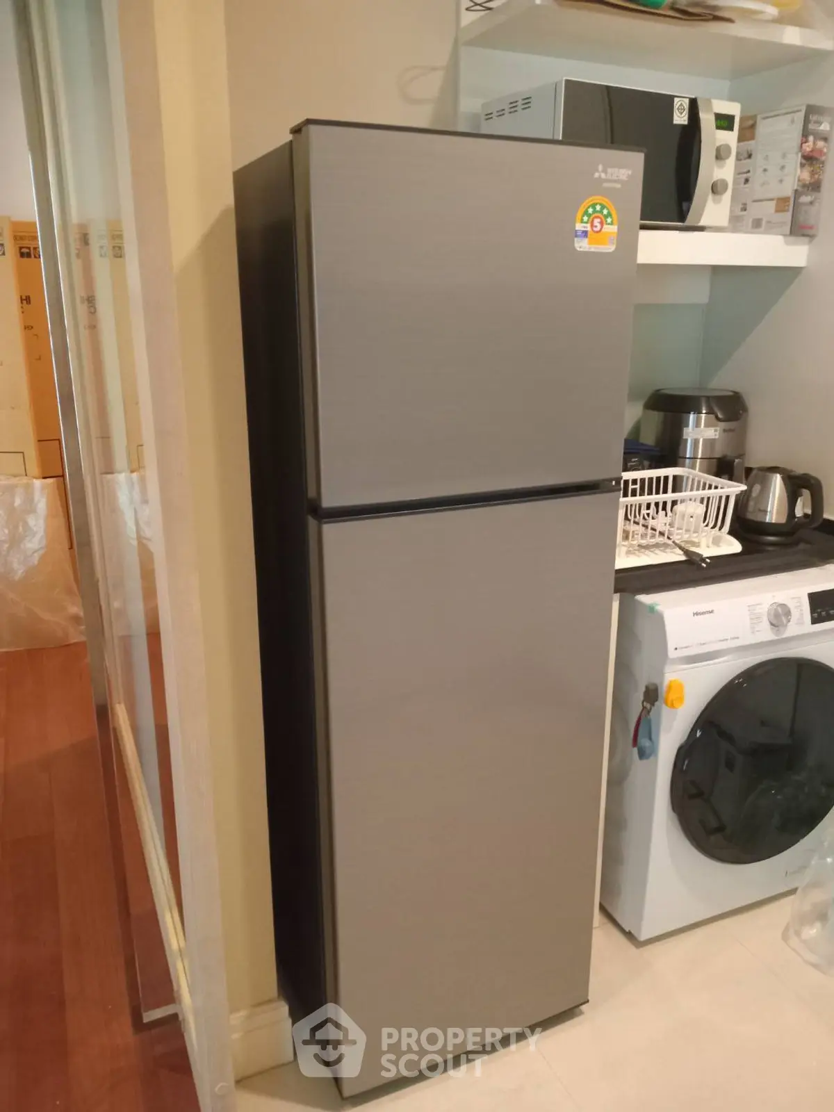 Modern kitchen with sleek fridge and washing machine, ideal for urban living.